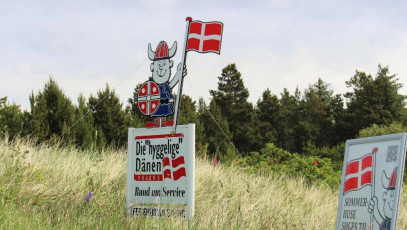 Skilt med en viking på, som holder et Danmarks flag