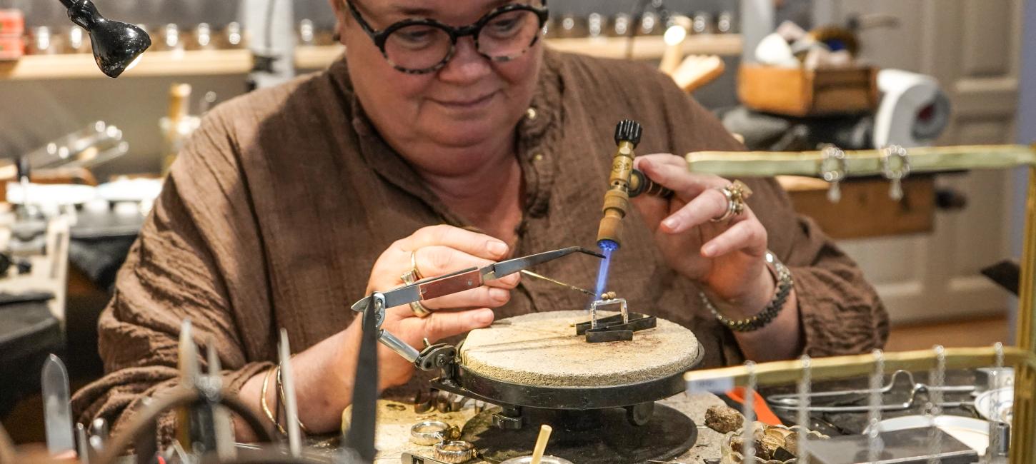 Kvinde står bag disk i smykkeforretning