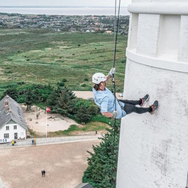 En kvinder som rappeller ned af et fyr