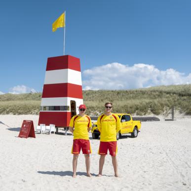 To livreddere står på stranden