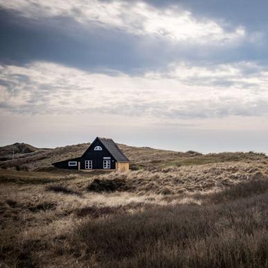 Udsigt til et gult feriehus og Henne Strand