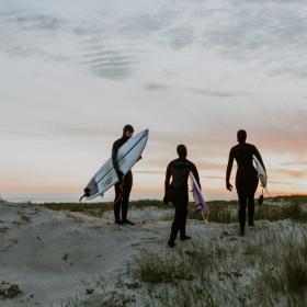 Surfers on a dune in sunset by the North Sea
