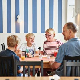 En familie som spiser morgenmad hos Lindvig Ferie